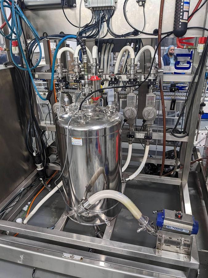 Used Apacks Six Head Automatic Mass Flow Meter Pressure Filling Machine, with conveyor