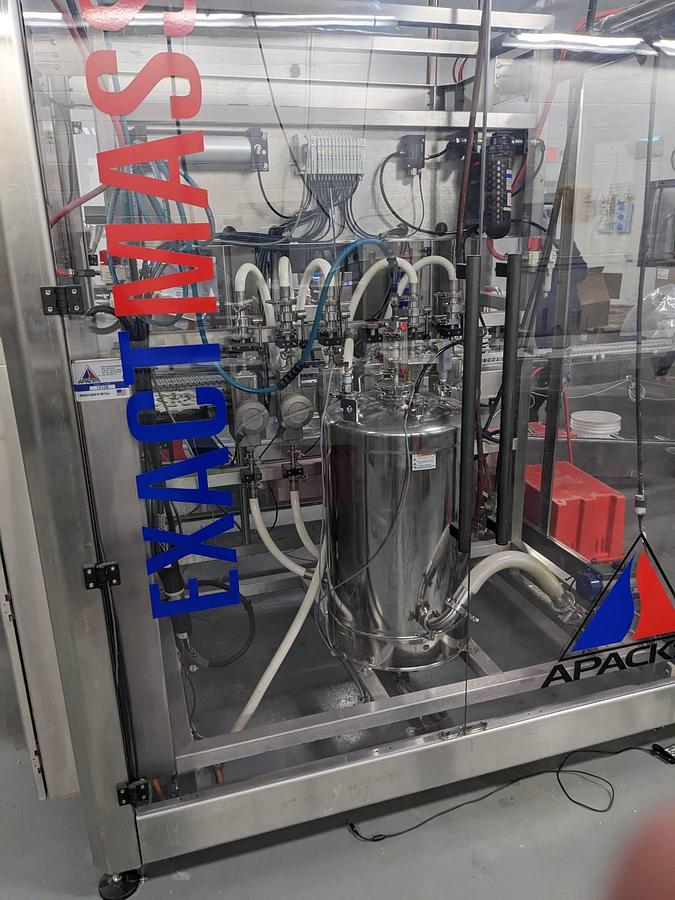 Used Apacks Six Head Automatic Mass Flow Meter Pressure Filling Machine, with conveyor