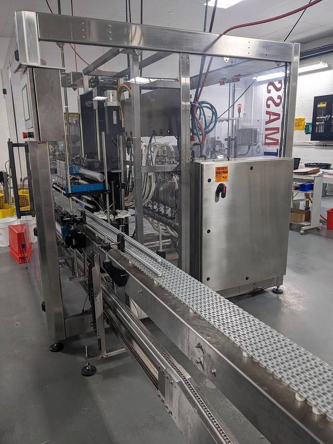 Used Apacks Six Head Automatic Mass Flow Meter Pressure Filling Machine, with conveyor