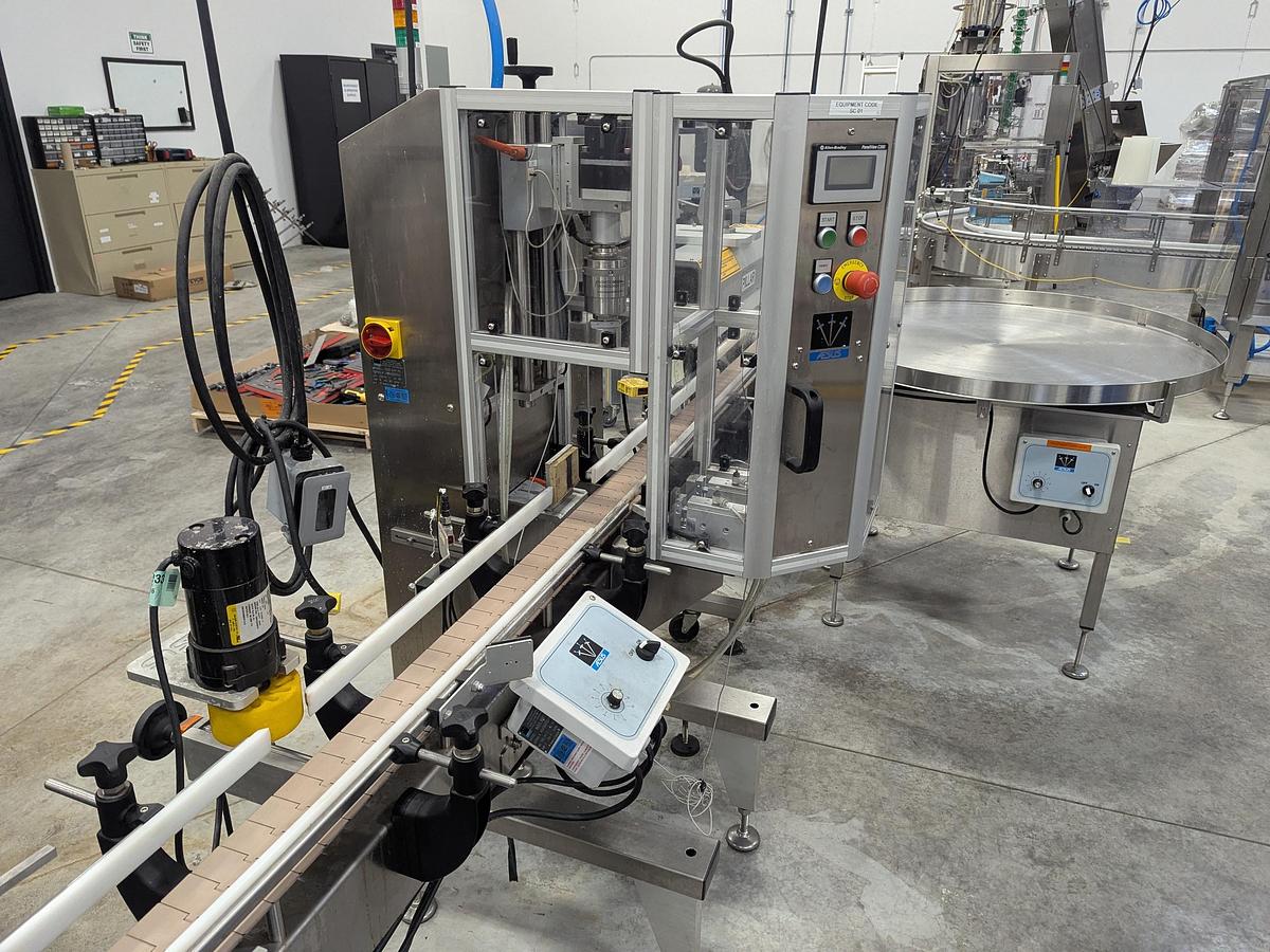 Used Aesus 6-Head Filling Line with Descrambler. Labeler, Filler, Capper, Induction Sealer & Accumulation Table