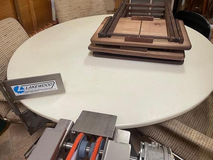 Used Lakewood Clamshell Filler with Infeed Conveyor & Accumulation Table