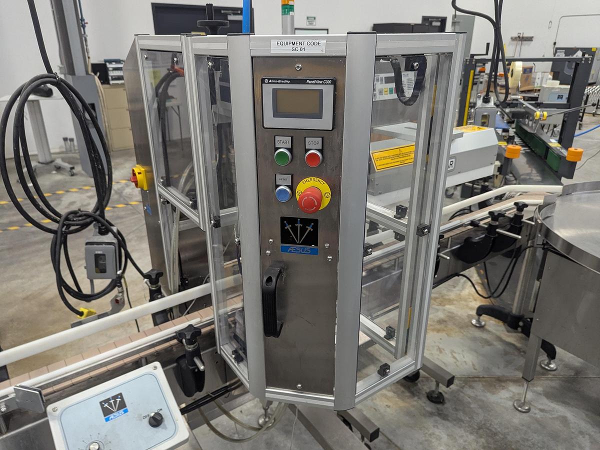 Used Aesus 6-Head Filling Line with Descrambler. Labeler, Filler, Capper, Induction Sealer & Accumulation Table