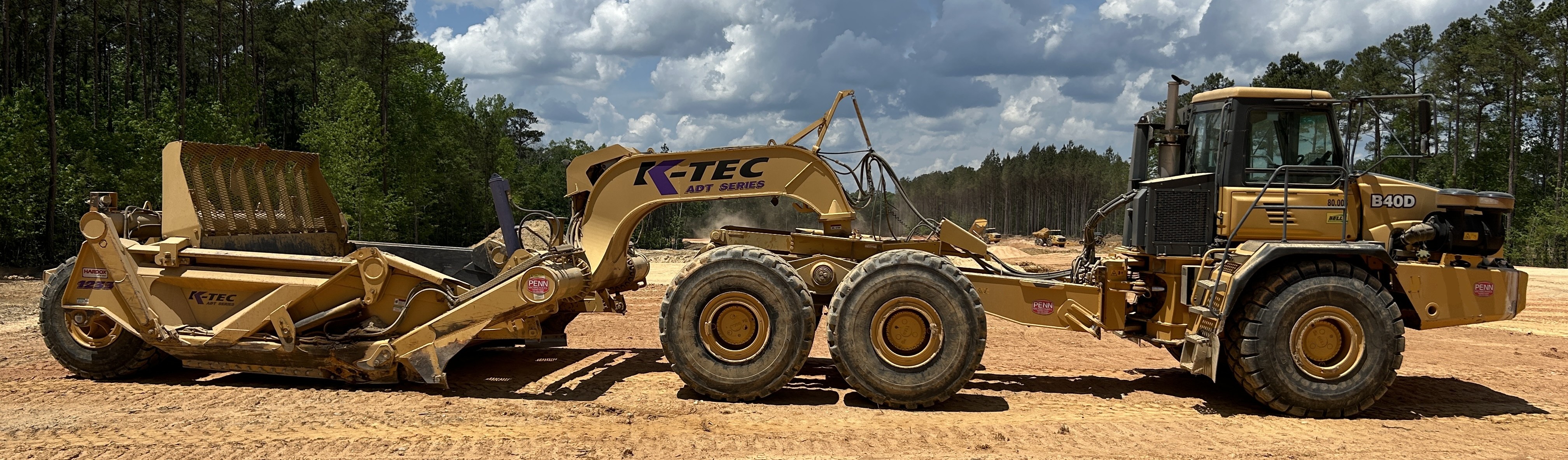 Used 2016 K-Tec K-Tec 1233 ADT scraper pulled by 2016 Bell B40D articulated dump truck