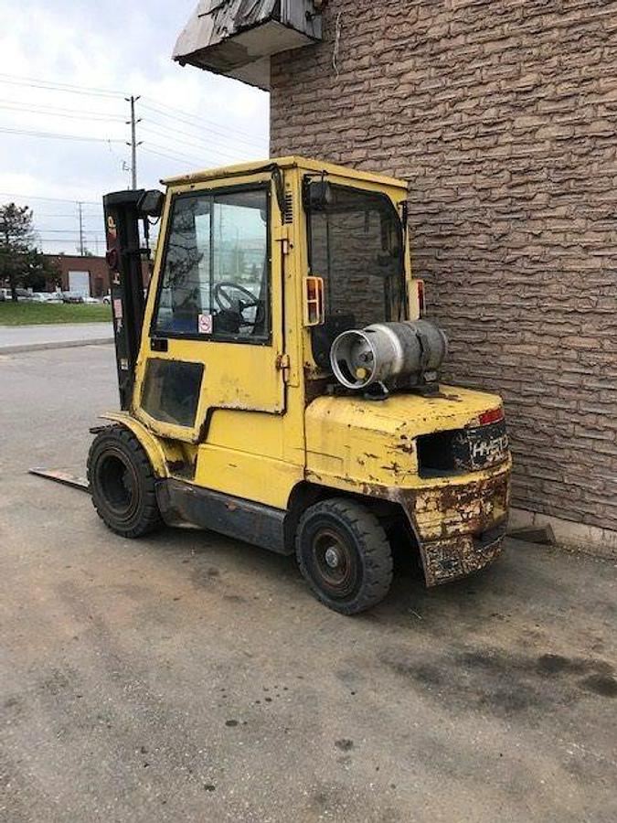 Opposite side view of refurbished 2000 Hyster H60XM LP Gas forklift showing counterweight, cab enclosure, and CSA certification decal during Erin, Ontario deployment.