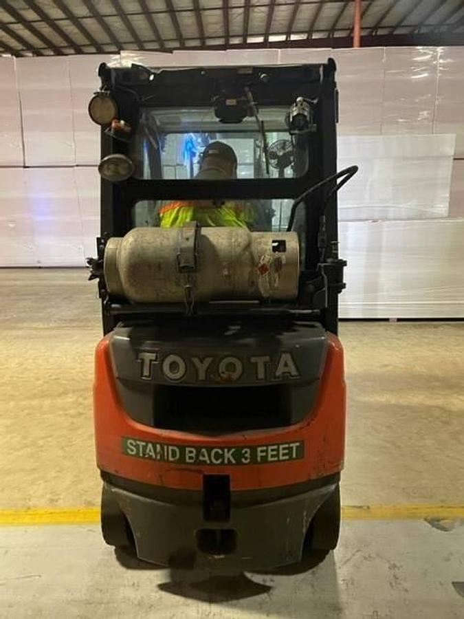 Back view of refurbished 2016 Toyota 8FGU15 LP gas forklift showing counterweight, propane tank mount, and CSA inspection tag during Brampton deployment