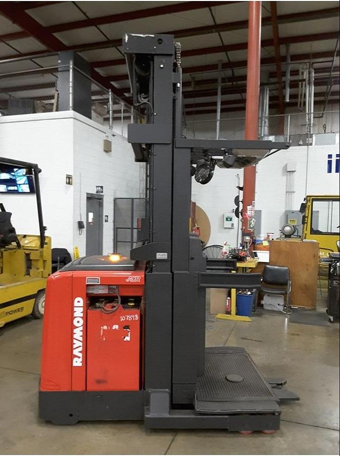 Opposite side view of refurbished 2011 Raymond 560-OPC30TT electric order picker showing battery enclosure, drive unit cover, and chassis structure during Toronto deployment