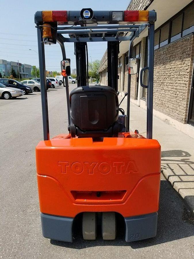 Rear view of Toyota 7FBEU15 electric forklift highlighting counterweight, safety decals, and CSA certification during warehouse deployment