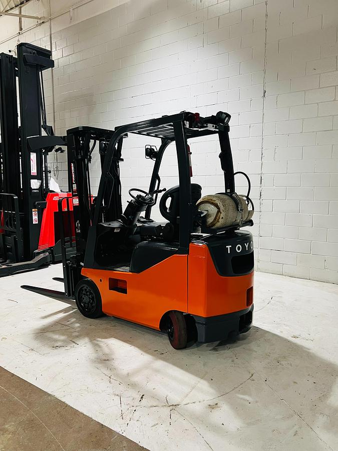 Rear side angle of 2020 Toyota 8FGCU18 propane forklift – CSA-certified 3,500 lb chassis showing counterweight, traction cushion tires, and propane tank bracket with safety decals applied, Brampton ON – Premier Lift Equipment