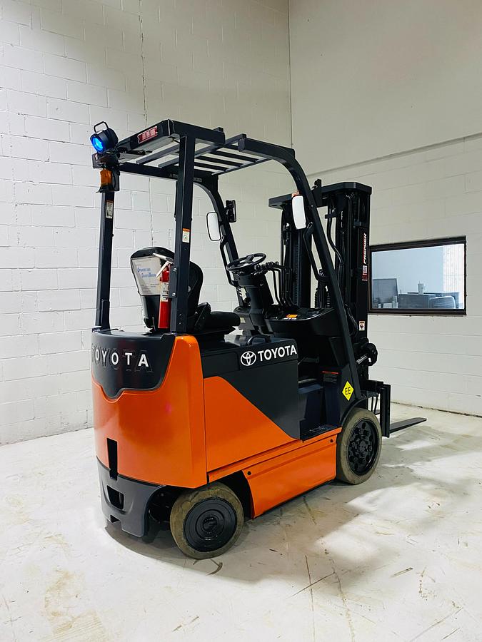 Opposite rear angled side view of Toyota 8FBCU20 COM electric sit-down forklift showing rear counterweight, safety lights, and CSA-certified frame – unit staged in Brampton ON