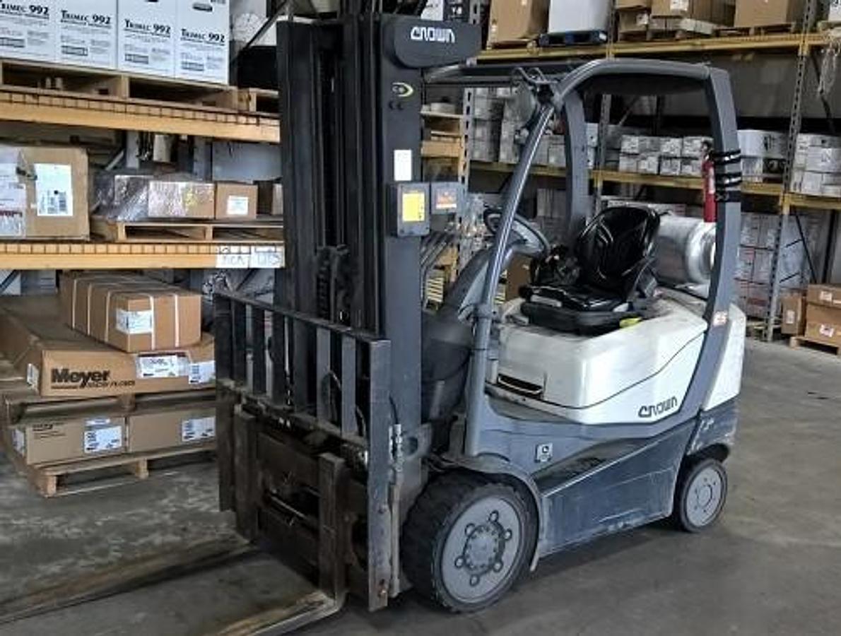 Front angled view of refurbished 2015 Crown C5100‑50 propane forklift showing triple side shifter, solid tires, propane tank mount, and CSA certification decal during Ontario deployment.