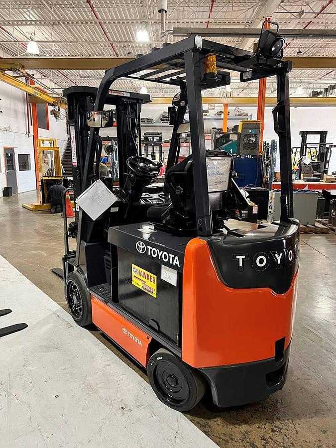 Rear side angle view of 2020 Toyota 8FBCU32 electric forklift showing counterweight, triple mast profile, and CSA decals during Brampton deployment
