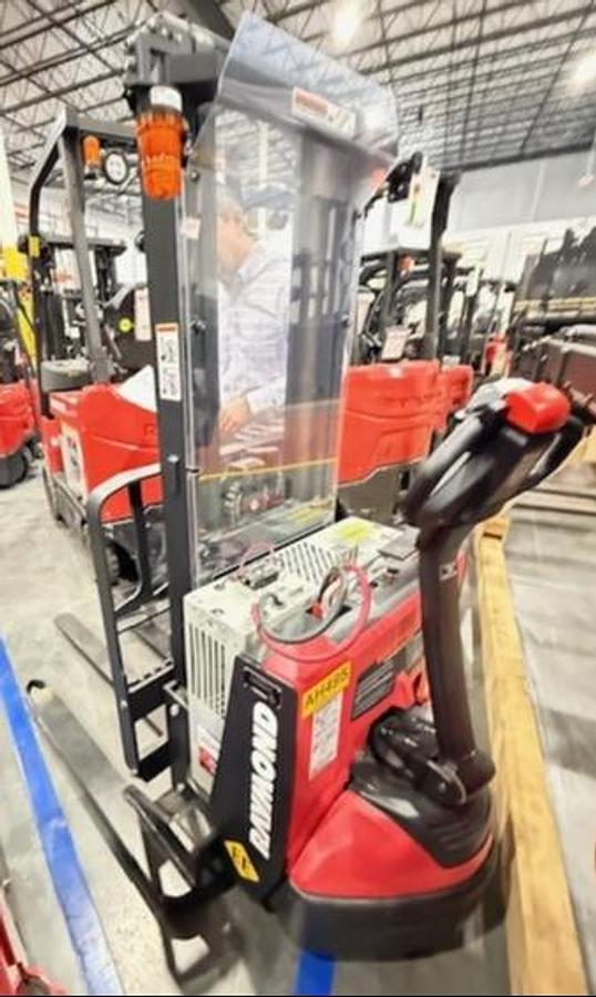 Side‑angle view of a CSA‑certified EE‑rated Raymond 6210 straddle stacker with enclosed electrical system for hazardous and controlled environments