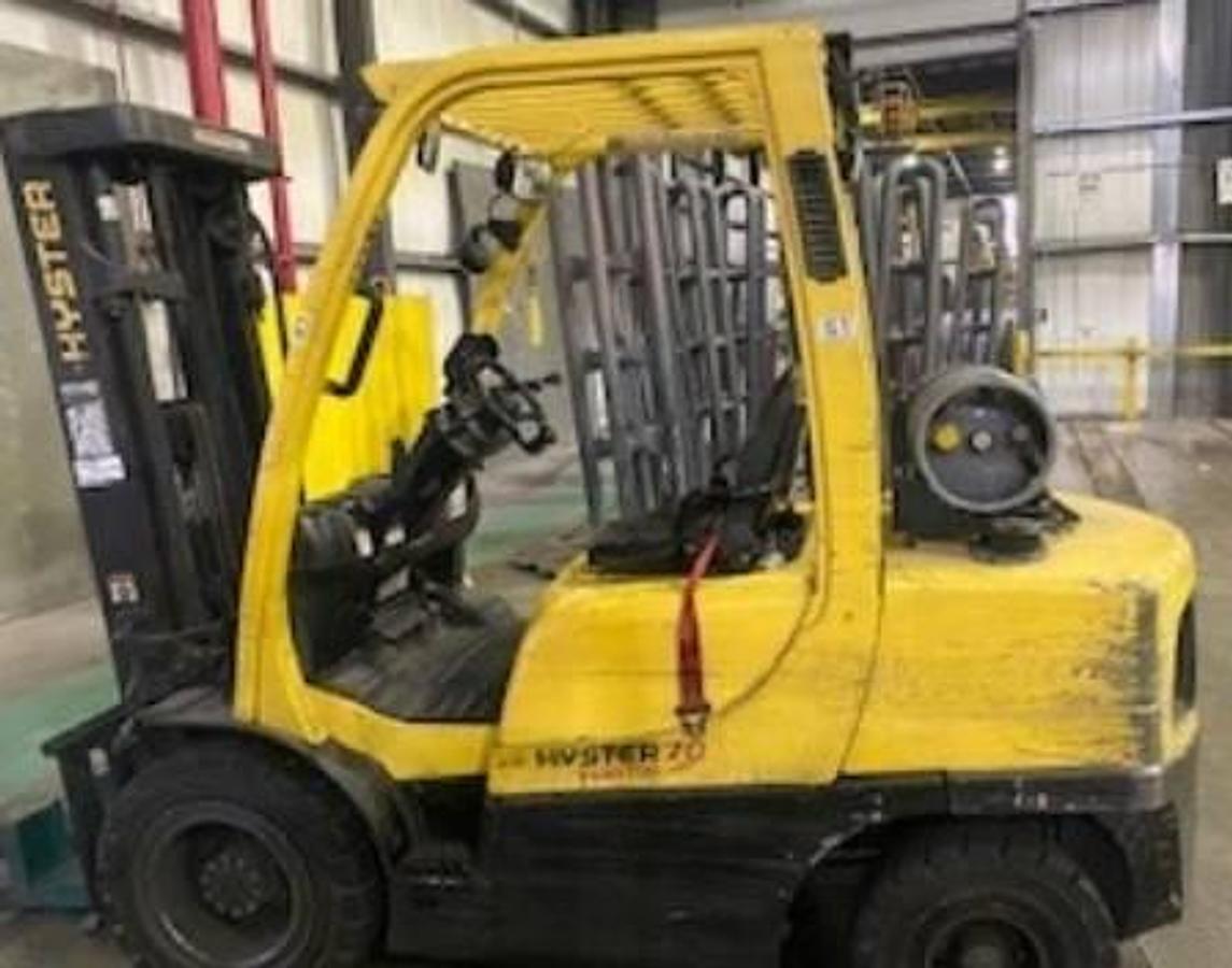 Side view of refurbished 2018 Hyster H70FT LP Gas forklift showing full cab, solid pneumatic tires, triple stage mast, and CSA certification decal during Ontario deployment.