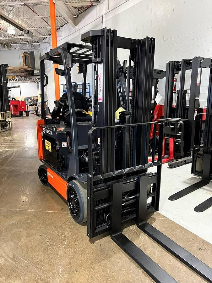 Head-on view of 2020 Toyota 8FBCU32 electric forklift with forks lowered, triple mast extended, and CSA safety markings visible