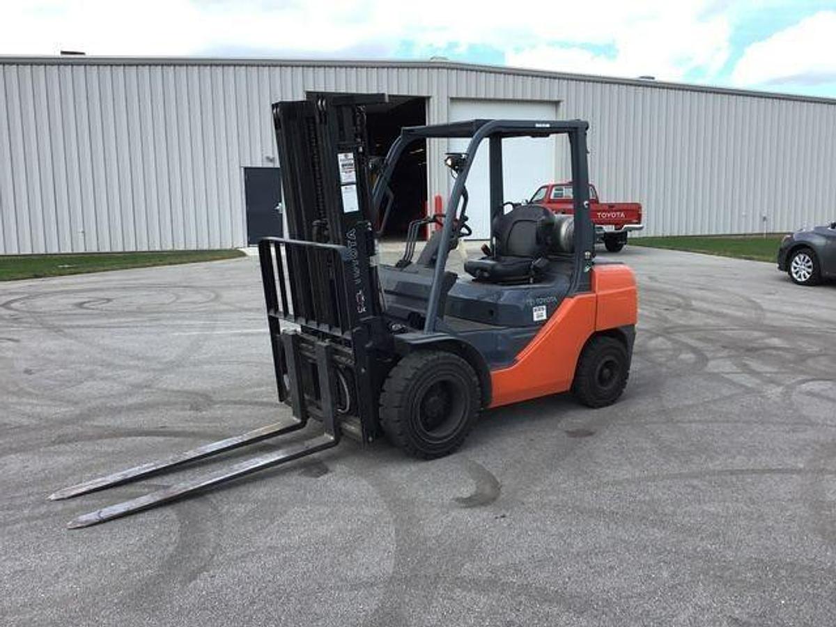 Opposite front side view of refurbished Toyota LP gas forklift showing mast, forks, operator cab, and solid tire chassis during Brampton deployment