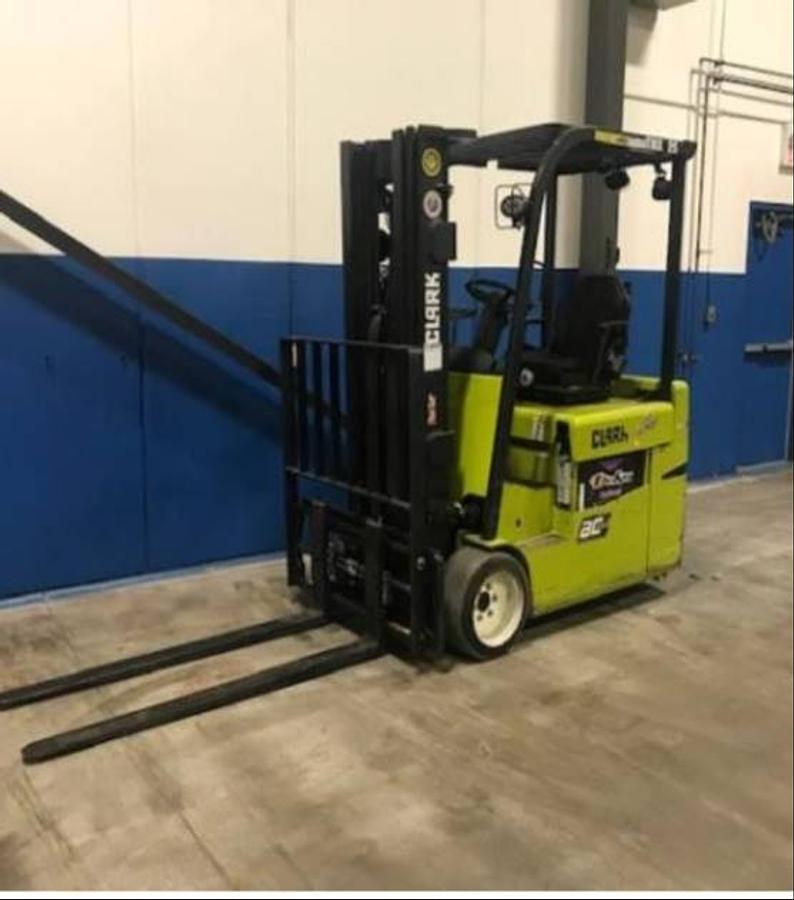 Angled front side view of Clark TMX25 electric sit-down forklift showing triple-stage mast, 42” forks, cushion tires, and CSA-certified chassis – unit staged in Brampton ON