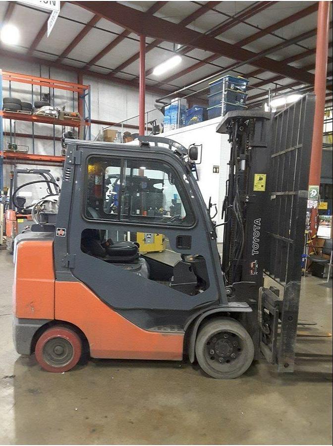 Opposite side view of refurbished 2011 Toyota 8FGCU32 LP gas forklift showing full cab enclosure, rear chassis, and CSA decal during Brampton deployment