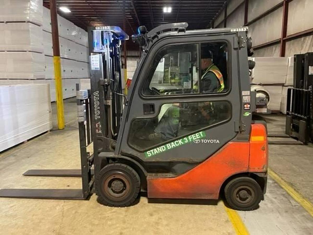 Side view of refurbished 2016 Toyota 8FGU15 LP gas forklift showing full cab, chassis, and triple mast during Brampton deployment