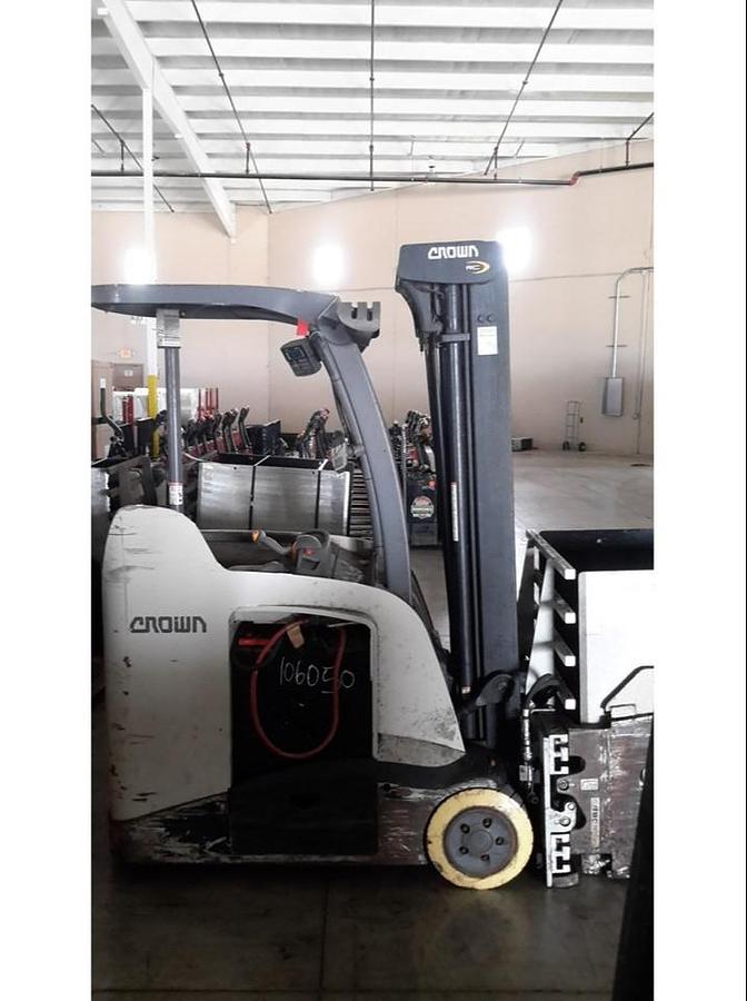 Side view of refurbished 2014 Crown RC5545‑40 electric forklift showing chassis, 3‑stage mast, 4‑way hydraulics, 36 volt battery compartment, and CSA certification decal during Ontario deployment.