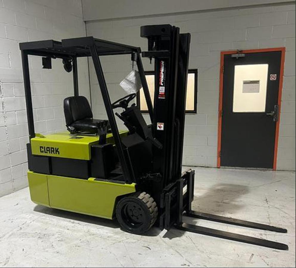 Budget Clark TM20 3‑wheel electric forklift with used battery and charger, older non‑CSA unit ready for light‑duty indoor work.