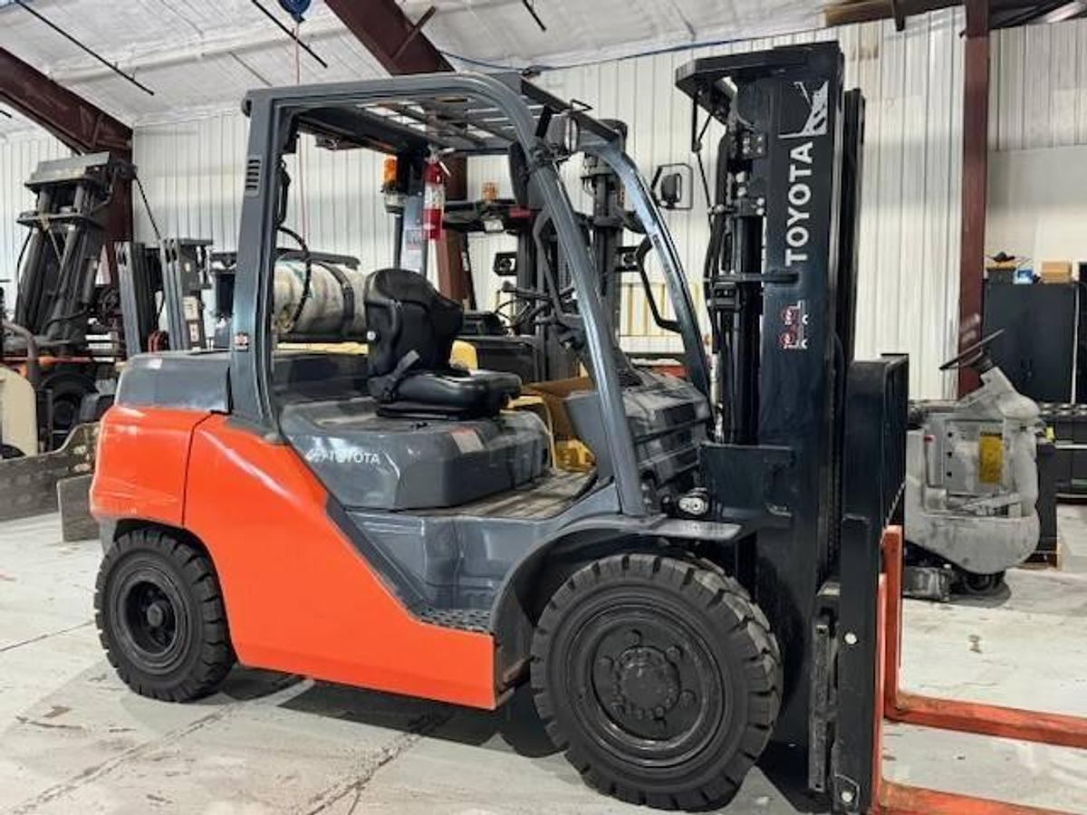 Side view of refurbished Toyota LP gas forklift showing operator cab, chassis, and triple mast during Brampton deployment