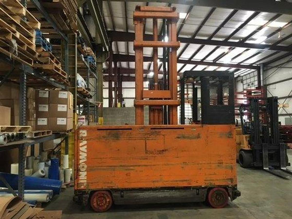 Rear view of Raymond 76-SL100TF sideloader showing counterweight, operator cab, and original decals during pre-refurbish staging