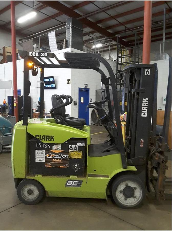 Side view of refurbished 2014 Clark ECX30 4‑wheel electric forklift showing 48 volt chassis, 4‑way hydraulics, and CSA certification decal during Brampton deployment.