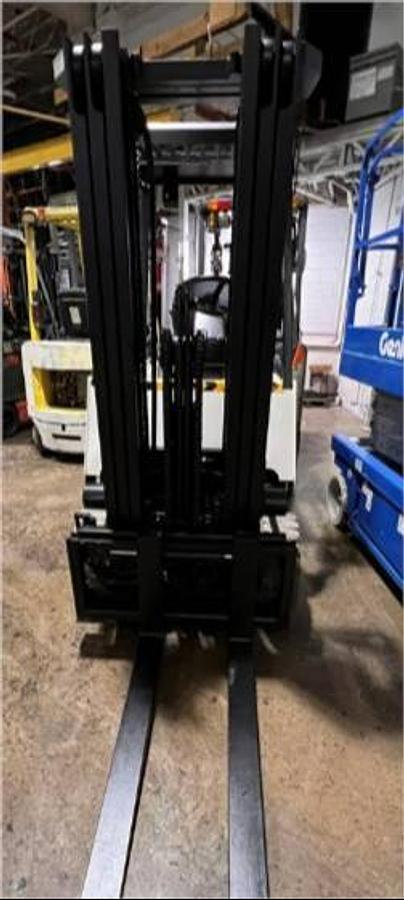 Front view of refurbished Nissan CWPG2L25S electric 4‑wheel forklift showing 188" triple mast, load backrest, and CSA certification decal during Brampton deployment.