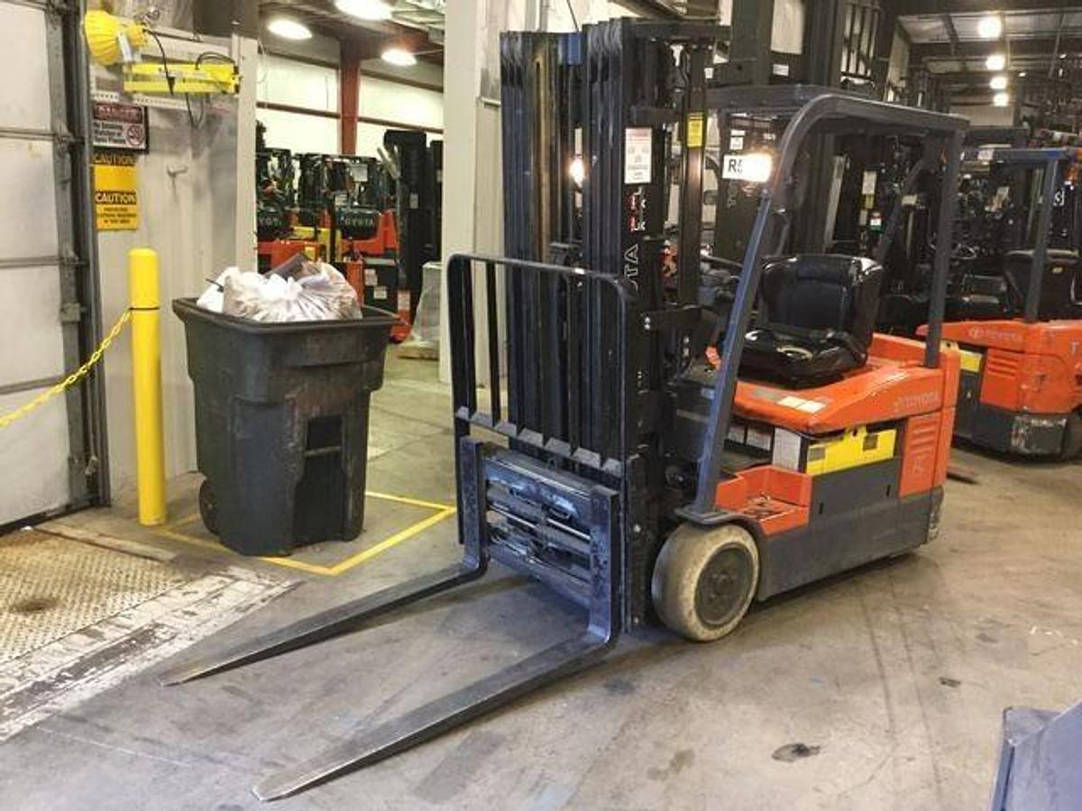 Profile view of 2015 Toyota 7FBEU20 electric forklift showing 3-wheel chassis, battery compartment, and quad mast configuration