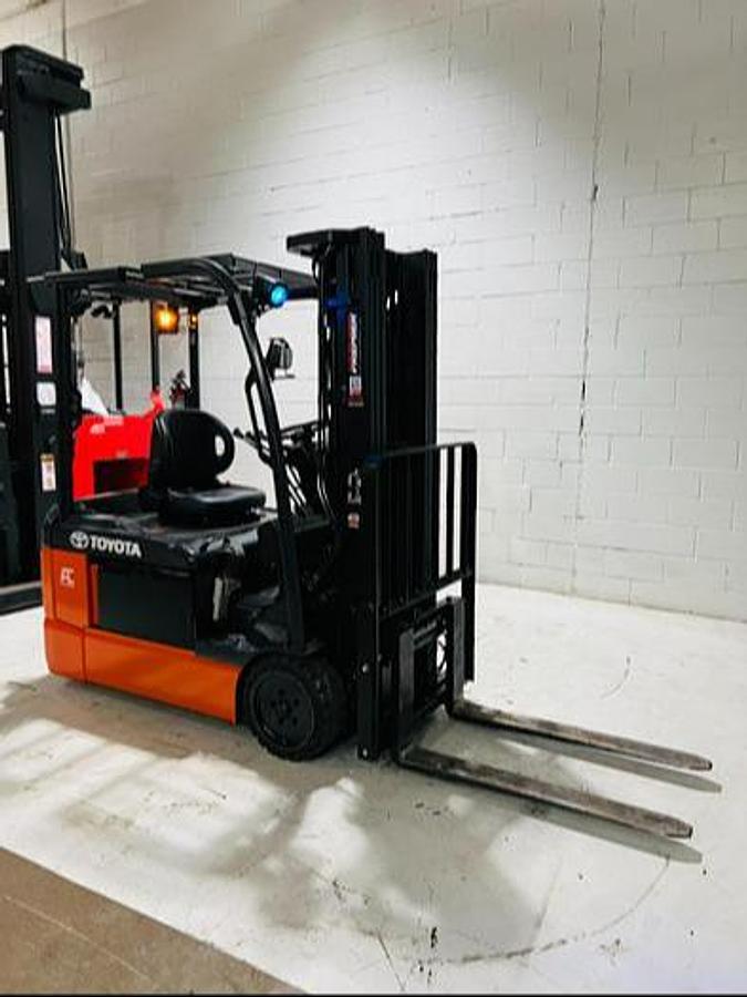 Opposite front side angle of refurbished 2023 Toyota 8FBE20U electric forklift showing mast, forks, operator cab, and 3-wheel chassis during Mississauga deployment