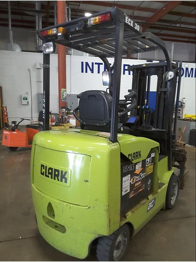 Rear side view of refurbished 2014 Clark ECX30 4‑wheel electric forklift showing rear chassis, battery compartment, and CSA certification decal during Brampton deployment.