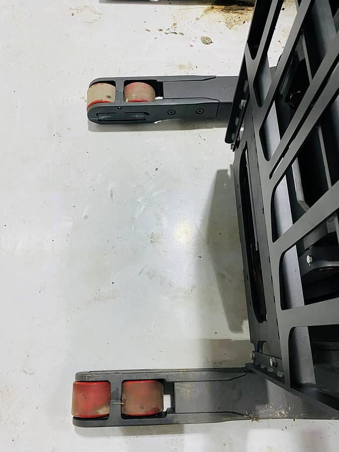 Low-angle view of refurbished 2022 Raymond 752 DR32TT deep-reach forklift showing straddle base legs with 41" base leg opening (BLO) and reach carriage during Brampton deployment