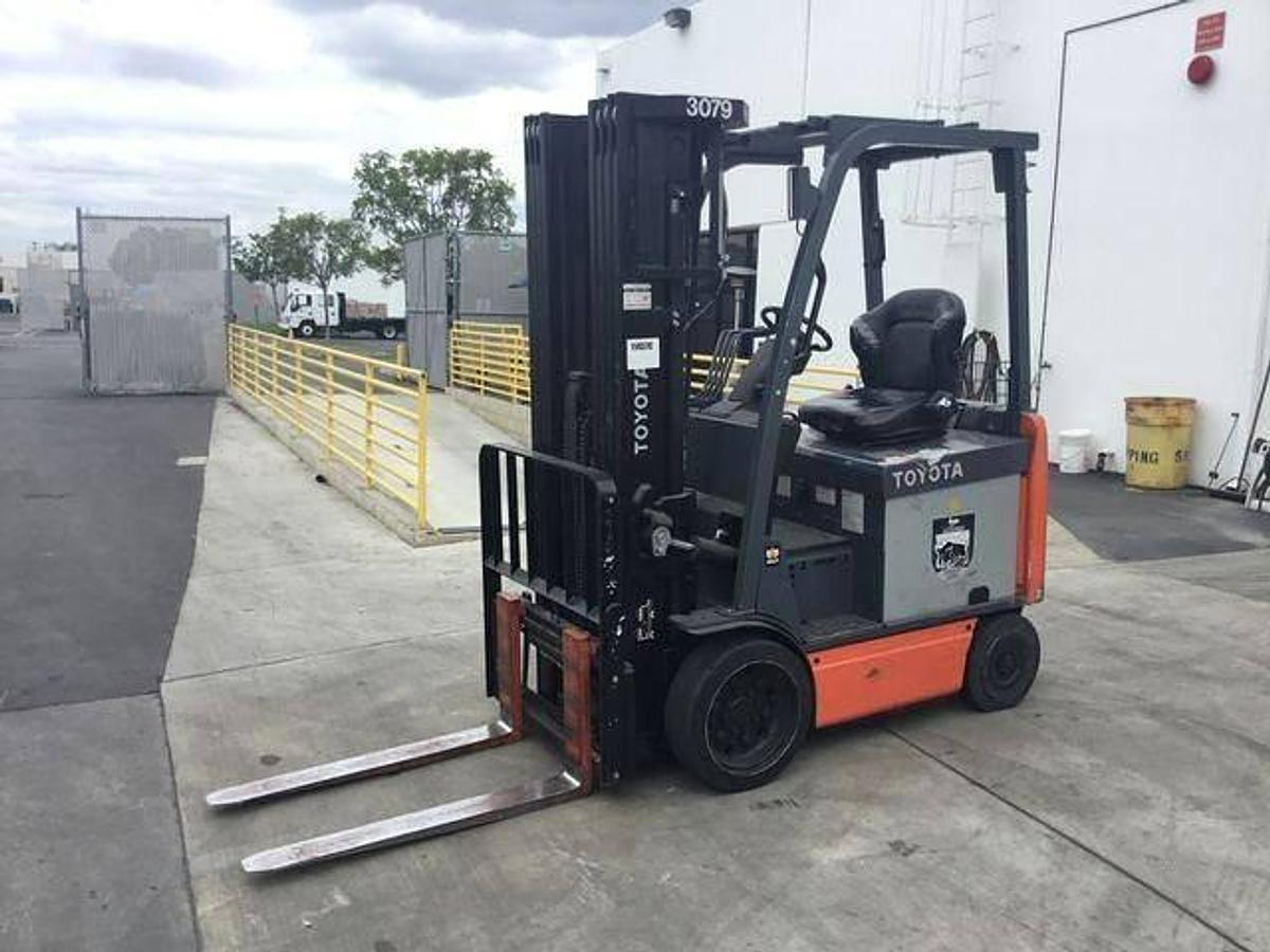 Side view of refurbished 2016 Toyota 8FBCU25 electric 4-wheel sit-down forklift showing quad mast, CSA decal, and side shift carriage during Ontario deployment