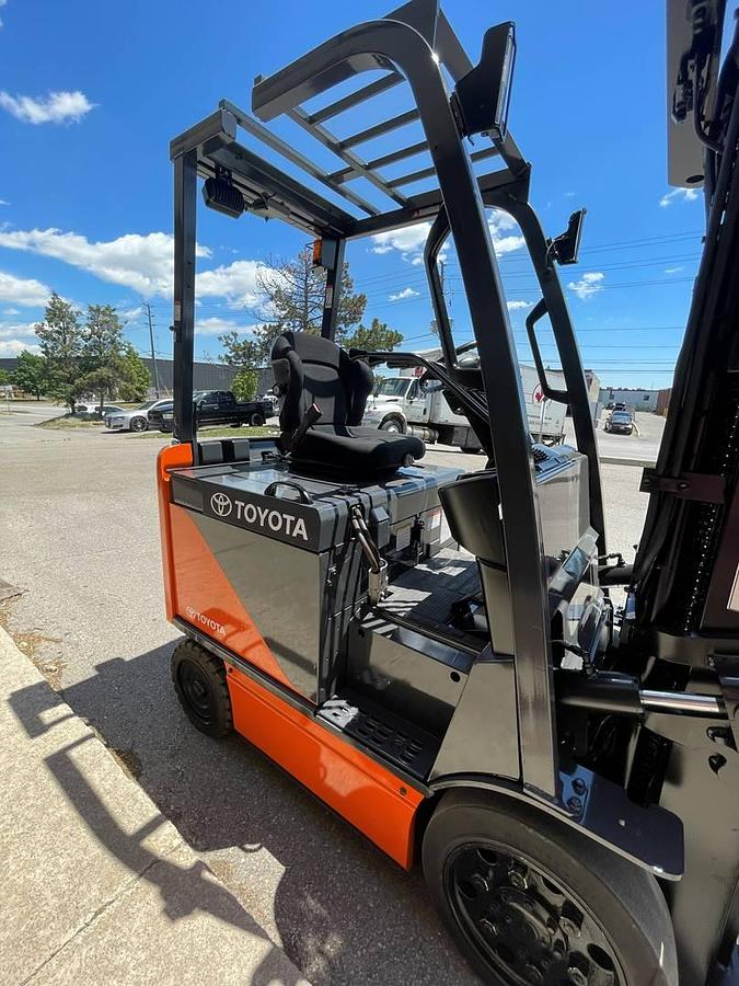 Opposite side view of 2017 Toyota 8FBCU25-EE electric forklift showing mast rails, CSA decals, and chassis profile during Brampton deployment