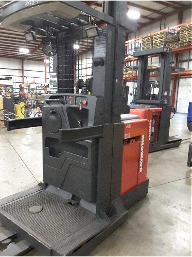 Front angle view of refurbished 2011 Raymond 560-OPC30TT electric order picker showing mast, forks, platform, and CSA inspection tag during Toronto deployment