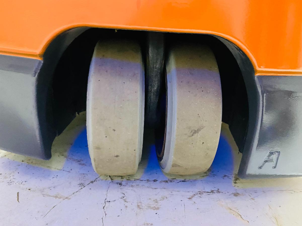 Rear view of 2012 Toyota 7FBEU15 electric forklift showing center-mounted 3rd wheel under counterweight for tight-turn maneuverability