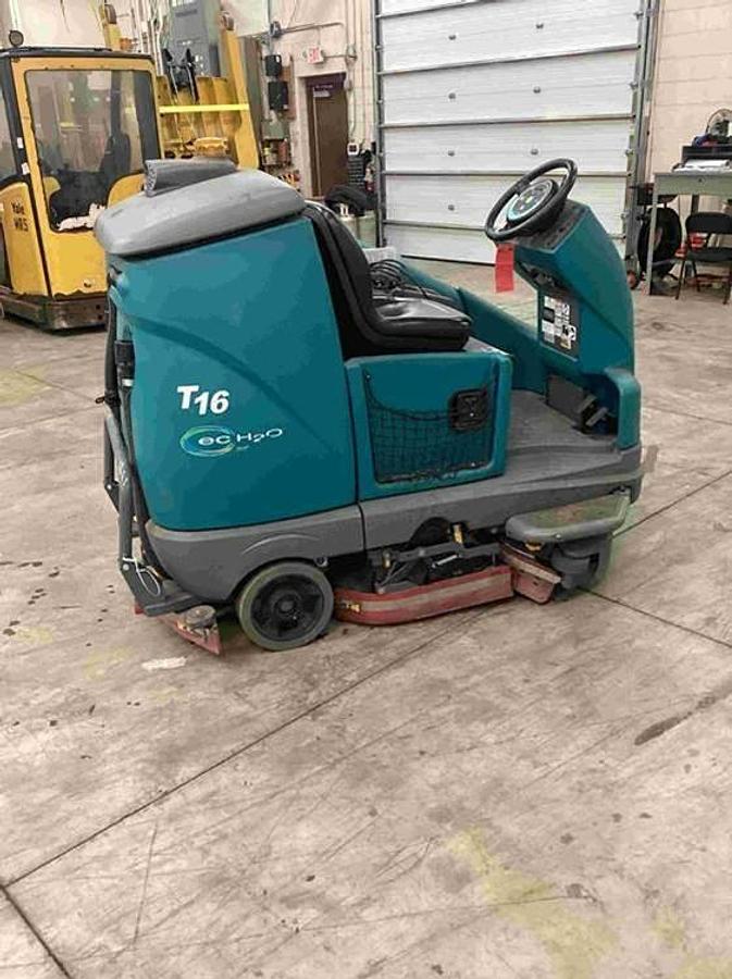 2018 Tennant T16 ride‑on floor scrubber front view – 36V battery, low‑hour industrial cleaning unit