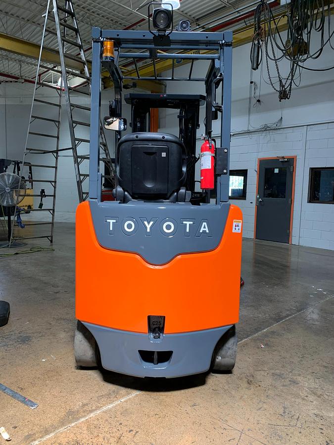 Rear view of Toyota 8FBCU25 electric forklift highlighting counterweight, safety decals, and CSA certification during warehouse deployment