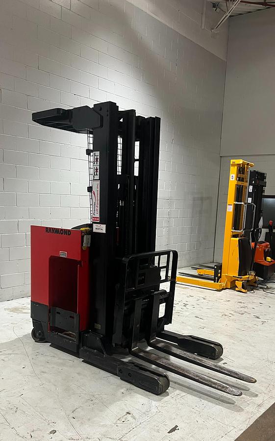 Front angle view of Budget Raymond reach truck — mast, carriage, and chassis detail.