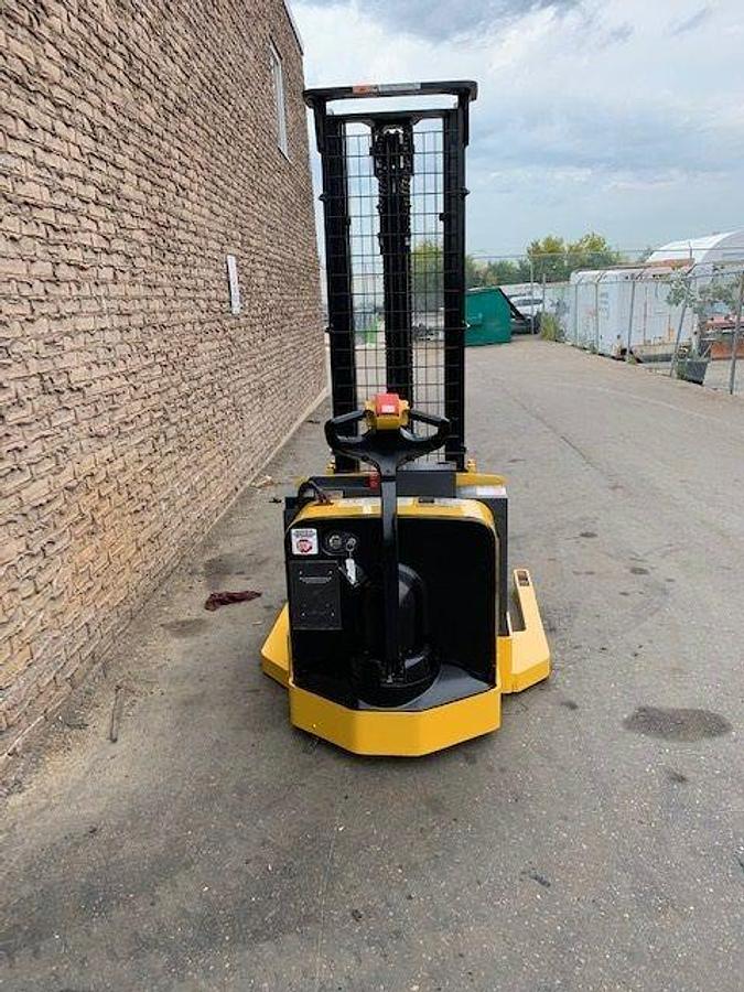 Back view of refurbished 2003 Yale MSW040 electric walkie straddle stacker showing operator handle, rear wheels, and CSA certification decal during Ontario deployment