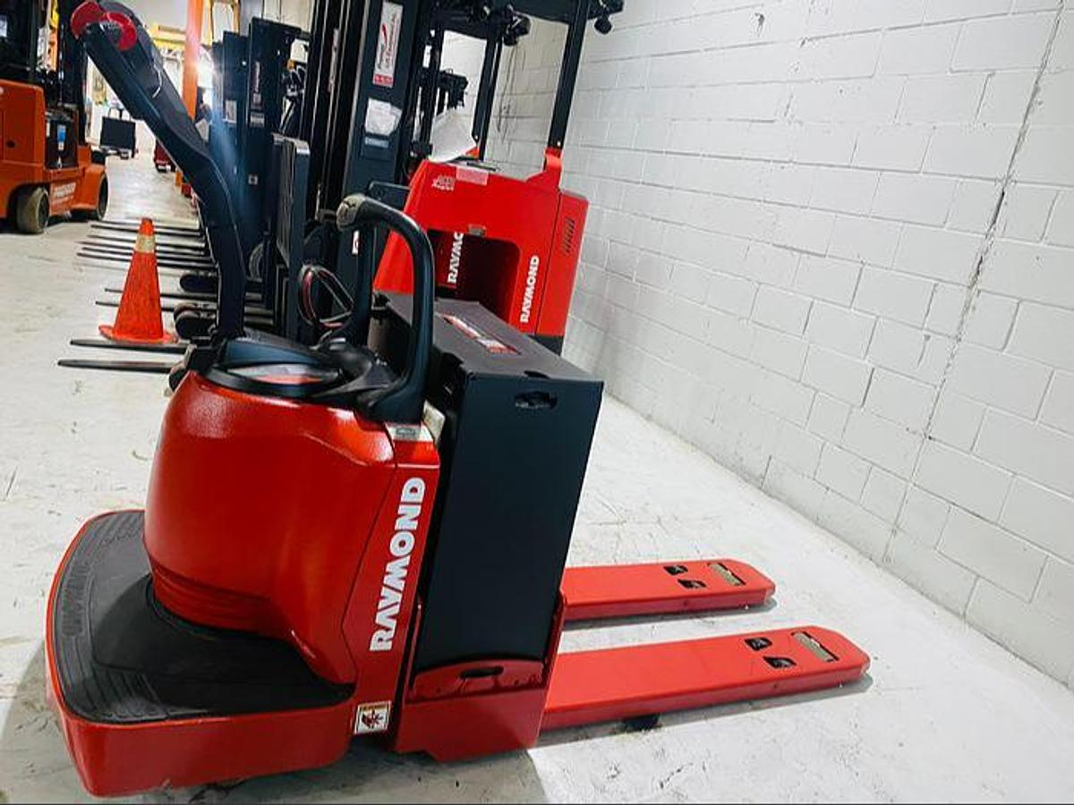 Close‑up opposite side view of Budget Raymond 8400 walkie pallet jack showing chassis and poly wheels.