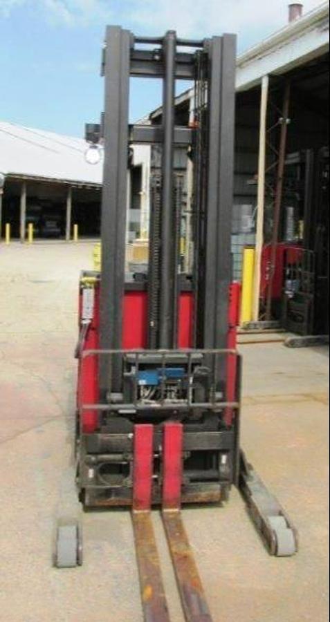 Front view of refurbished 2012 Raymond EASIR45TT electric reach truck showing triple mast, straddle base legs, fork positioner attachment, and side shift carriage during Mississauga deployment