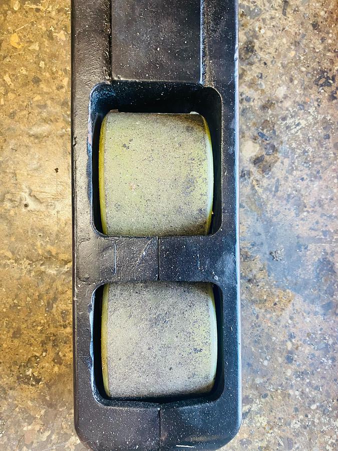 Close-up of Raymond 750-R45TT forklift straddle leg load wheels – poly cushion rollers mounted under baselegs for pallet support and smooth indoor travel