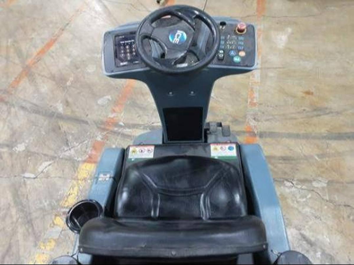 Operator compartment of refurbished 2019 Factory Cat RS25 electric rider sweeper‑scrubber showing steering wheel, electric controls, 26" wide cleaning path, 24 volt battery, and CSA certification decal during Brampton deployment