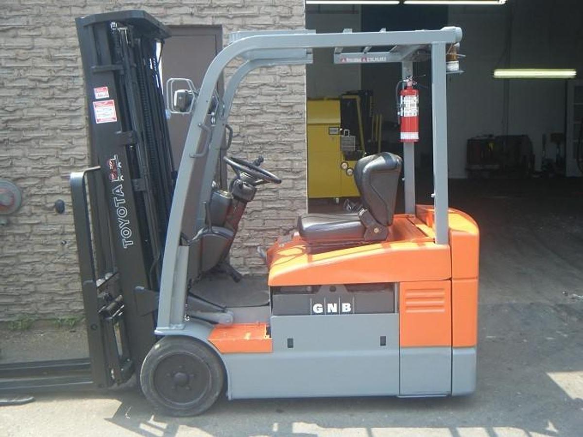 Profile view of 2012 Toyota 7FBEU20 electric forklift showing 3-wheel chassis, battery compartment, and side shift carriage