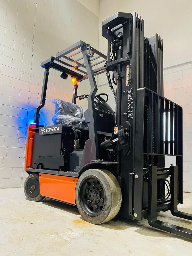 Front angled view showing mast rails and 42” fork tips with drive thru overhead guard