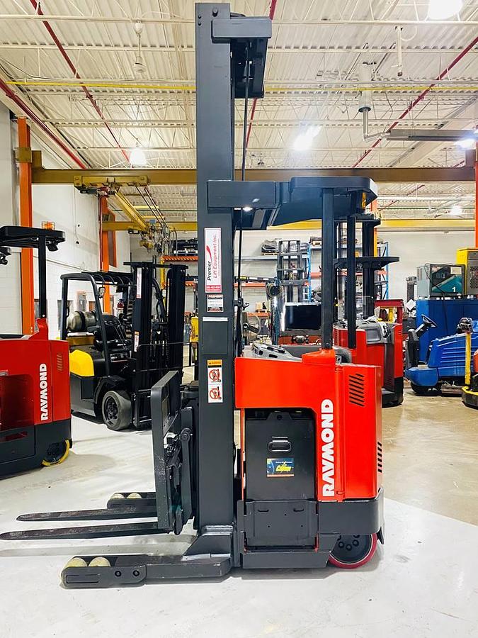 Alt="Side view of SOLD 2000 Raymond EASIR40TT CSA‑certified reach truck showing triple mast and forks in Brampton deployment"
