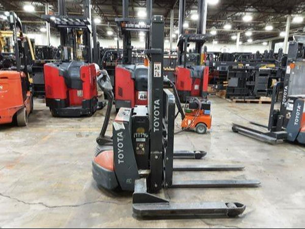 Side view of refurbished 2019 Toyota 8BWS13 electric walkie stacker showing mast rails, CSA decal, and compact chassis during Ontario deployment