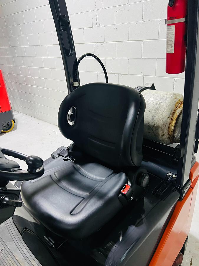 Close-up of new suspension seat on 2020 Toyota 8FGCU18 propane forklift – CSA-certified 3,500 lb chassis showing low-vibration operator station, overhead guard, and propane tank bracket with safety decals applied, Brampton ON – Premier Lift Equipment