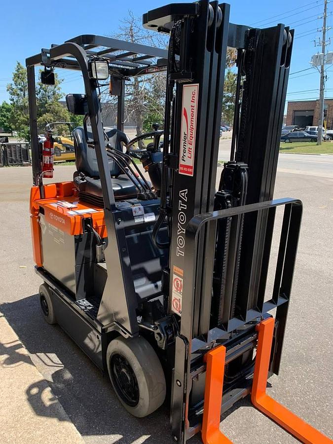 Front angle side view of refurbished 2008 Toyota 7FBCU18 electric 4-wheel sit-down forklift showing fork tips, mast extension, and CSA certification decal during Ontario deployment